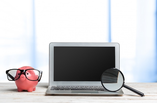 A laptop displaying a tax return form, with a magnifying glass hovering over it, suggesting careful review.