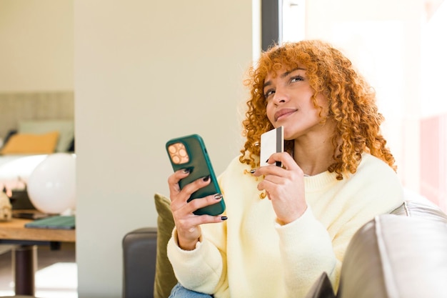 A person holding a credit card and using a smartphone with a financial app, focusing on optimizing spending and reducing debt.