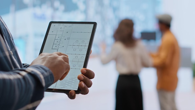 A screenshot of a project management app on a tablet, showing a Kanban board with tasks assigned to different team members. The app displays deadlines, progress bars, and communication features.