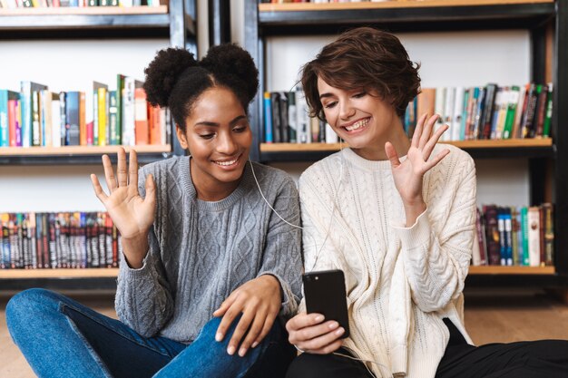 Two people from different cultural backgrounds happily using a language exchange app on their phones, showcasing the interactive and global aspect of language learning.