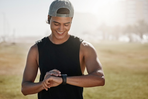 A person wearing a smartwatch and using a fitness app on their phone while running outdoors. The app displays real-time stats such as pace, distance, and heart rate. The background is a scenic urban park.
