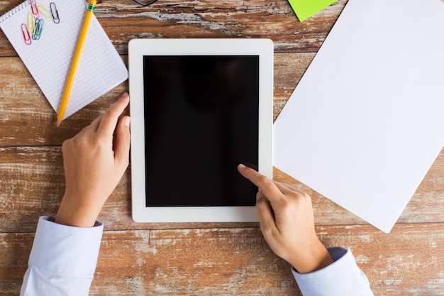 A close-up of a hand holding a tablet with a reading app open, showcasing highlighting and note-taking features on a page of text.