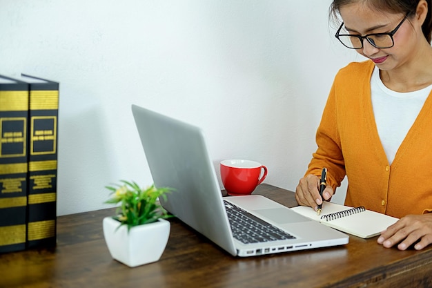 A person working at a clean, organized desk with a laptop, notebook, and pen. A smartphone displays a task management app with a completed checklist showing a sense of accomplishment. Natural light fills the room, highlighting the organized workspace.