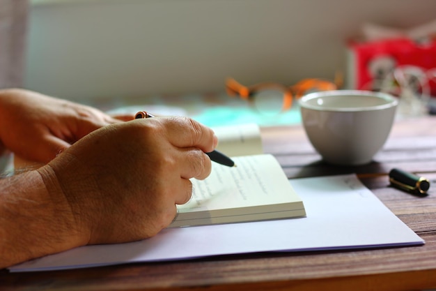 A close-up of a hand filling out a form at a table. the form shows details to be completed, such as name, address, social security number and family income. The atmosphere is focused and serious. The image emphasizes the attention to detail required when submitting documents for social security benefits.