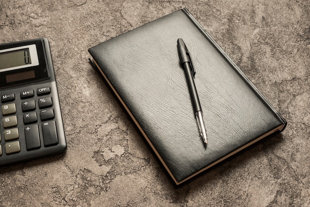 A close-up of a calculator with financial documents and a pen resting on top. Focus on the numbers and symbols representing financial calculations. Ensure the image conveys precision and accuracy.