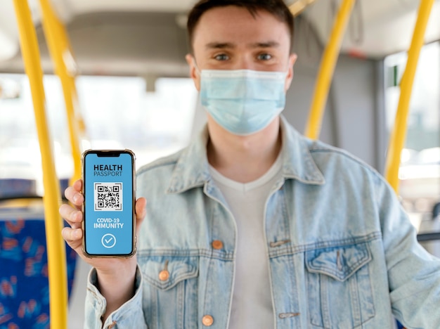 A person holding a smartphone displaying the ID Jovem app with a QR code. The background is a blurred image of a bus station, suggesting travel accessibility.