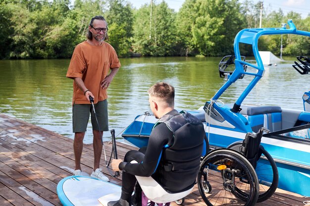 A person using a wheelchair enjoying a boat tour on the Amazon River, highlighting accessible adventure tourism in the Brazilian rainforest. Include lush greenery and wildlife in the background, showcasing the natural beauty of the environment