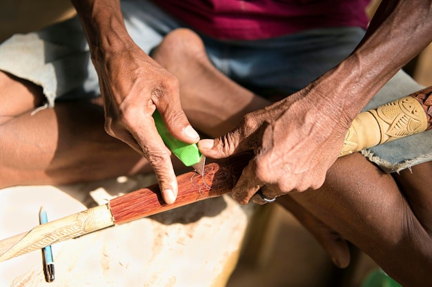 Close-up of a local artisan in a small village in Brazil, crafting a traditional handmade basket using sustainable materials, with a focus on the preservation of cultural heritage and promotion of ethical and eco-friendly tourism.